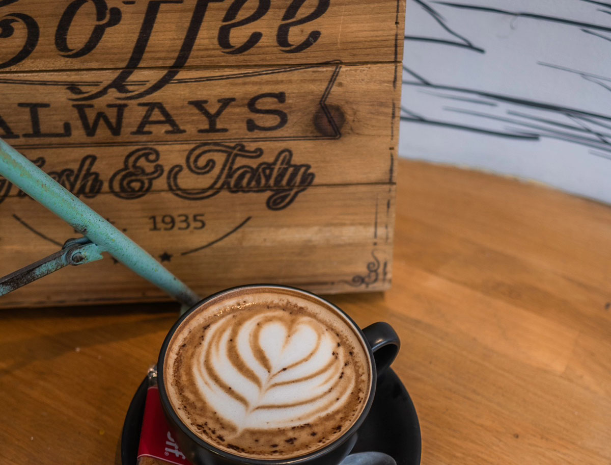 Fresh espresso pouring into a dark ceramic cup
